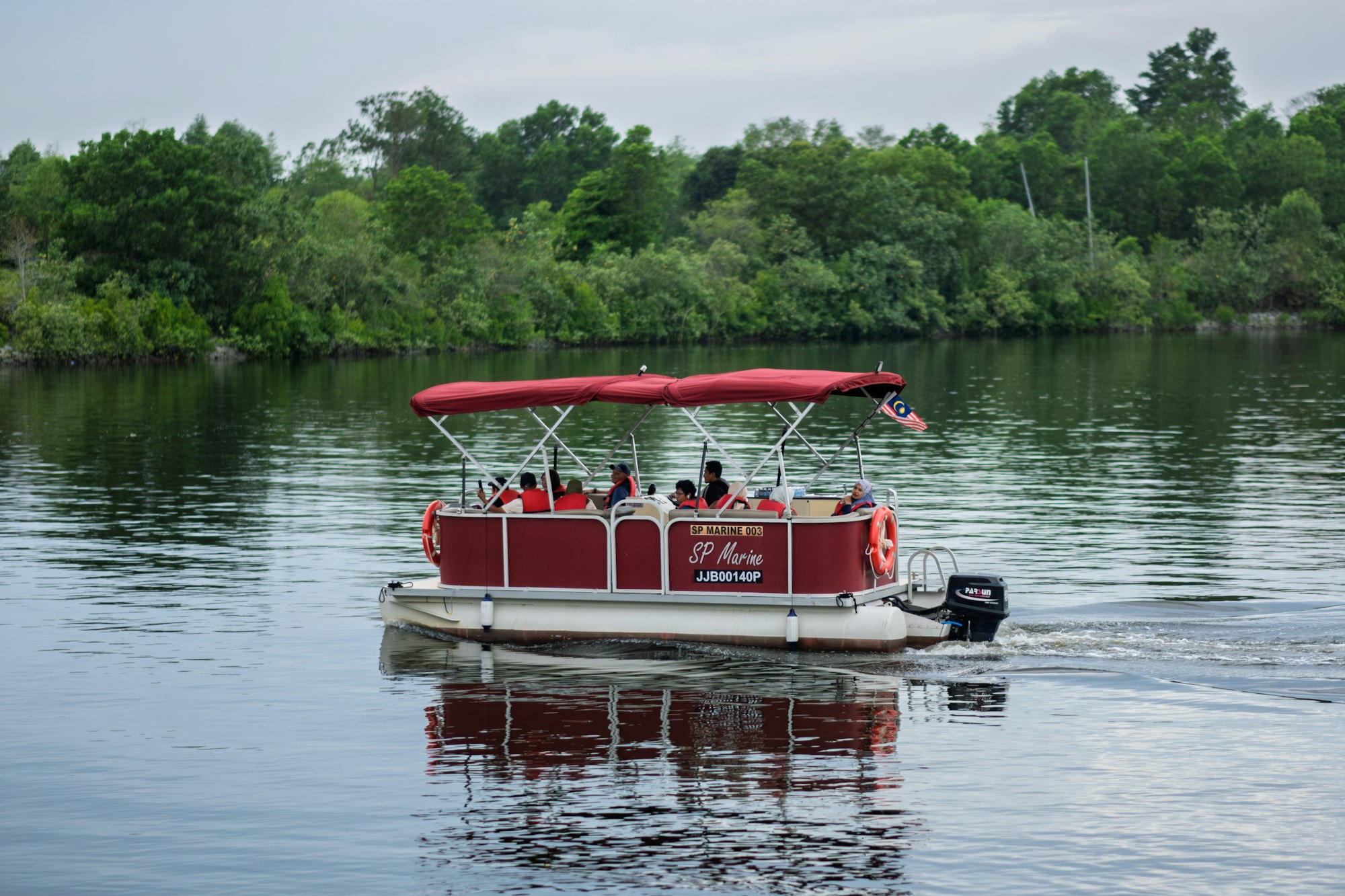 A family out on a red pontoon